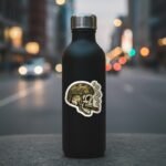 Tactical skull sticker on a black water bottle on a city street at dusk