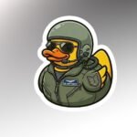 Die-cut sticker of a rubber duck in an olive flight suit, helmet, headset and sunglasses with a U.S. Air Force name tape