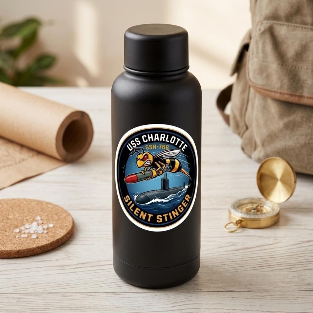 USS Charlotte Silent Stinger sticker on a black water bottle next to a compass and a canvas bag